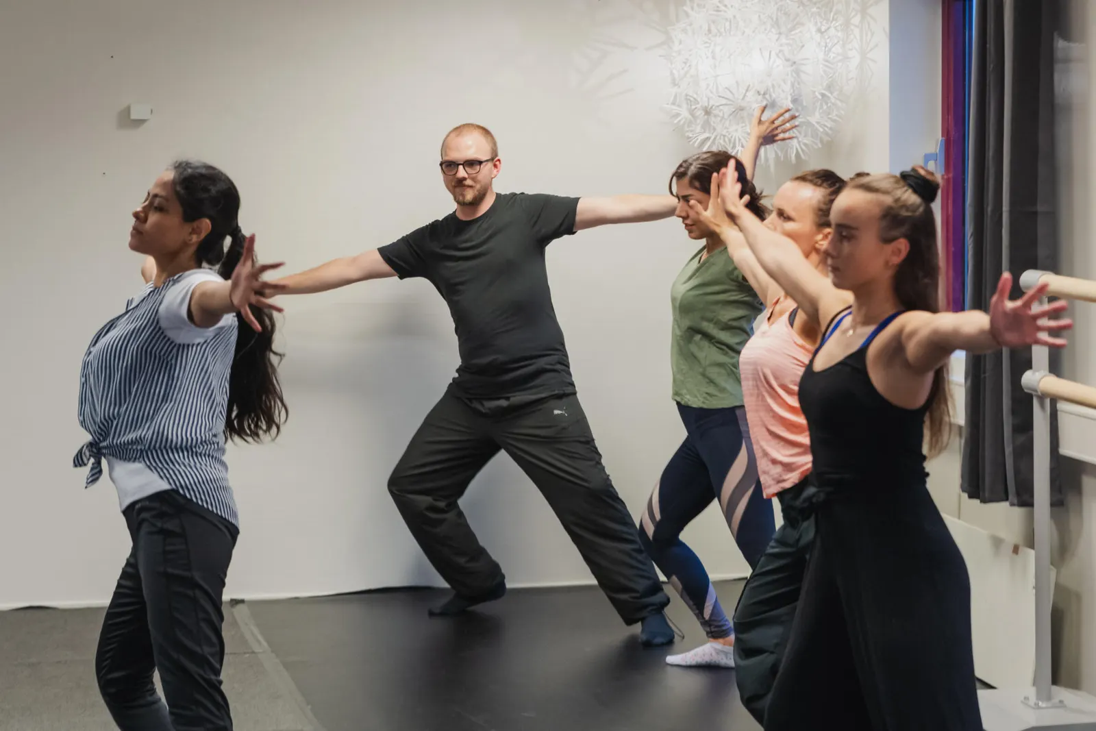 A teacher leading a contemporary class through a wide arm movement