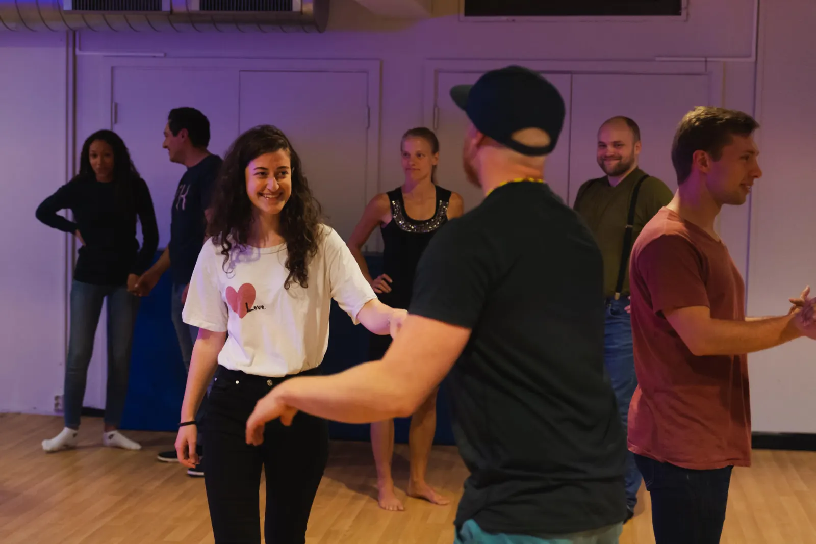 Students pairing up and laughing during a partner dance class